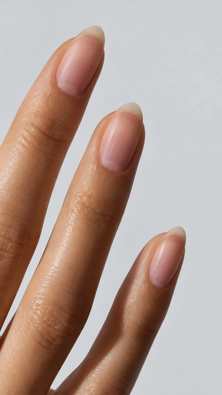 Unghie naturali sane Primo piano di unghie femminili naturali, sane e senza smalto, dalla forma a mandorla, con superficie regolare e colore rosato
